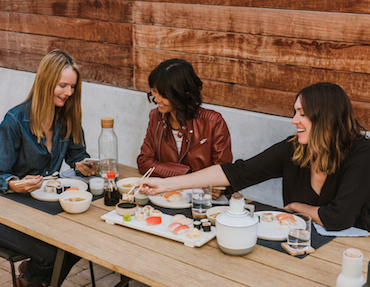 Women enjoying sushi at restaurant